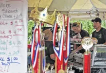 
			
				                                Bill Cost, seen through prior years’ trophies won by Bosak’s, takes an order for kielbasa during the Plymouth Alive Kielbasa festival in 2019. This year’s festival is set for Aug. 11-12.
                                 Times Leader file photo

			
		